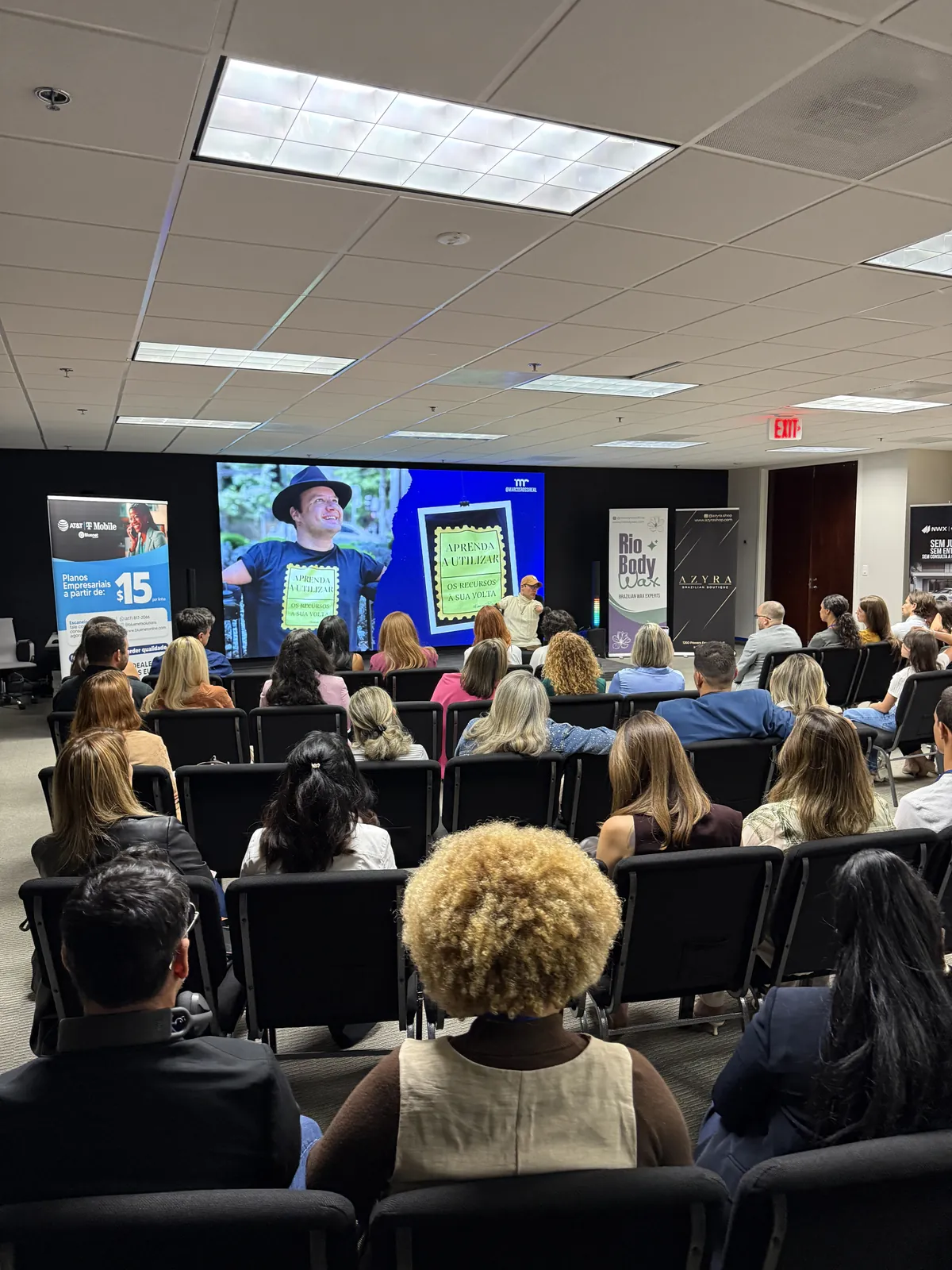 A full room watching a large screen