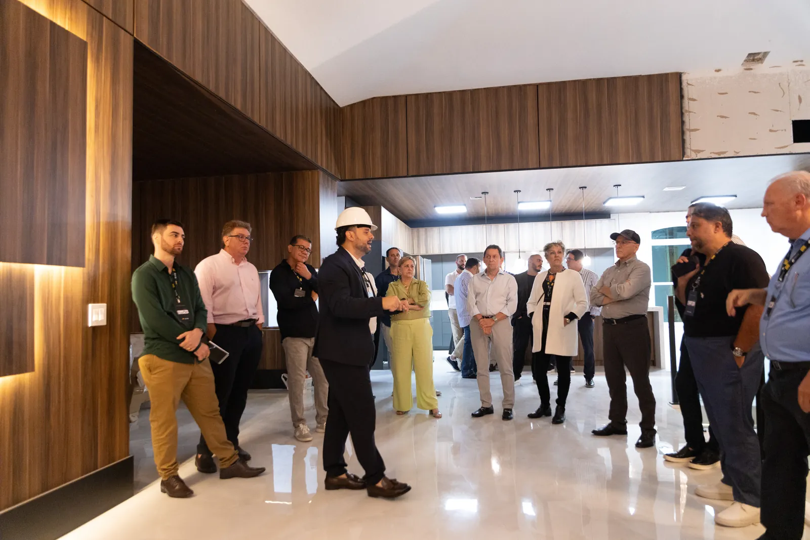 A guided walk-through of a property in the finishing stage: the presenter in a hard hat, a group of visitors listening